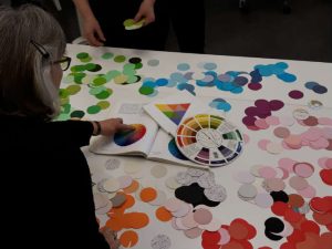 Pöydällä kantongista leikattuja ympyröitä, paljon värejä. Ympyröitä käytettiin väriharjoitustehtävässä.