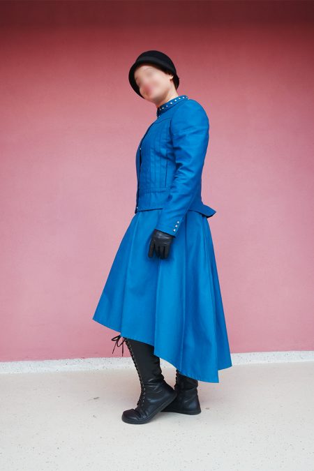 Kuva sivulta, petroolinsininen jakku ja laskoshame.