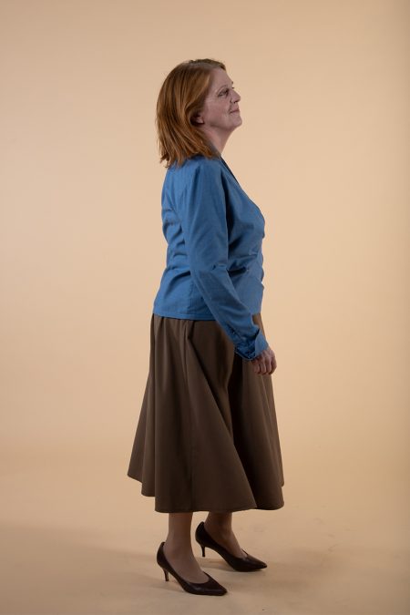 Kuva sivulta, sininen kietaisupaita ja ruskea hame.