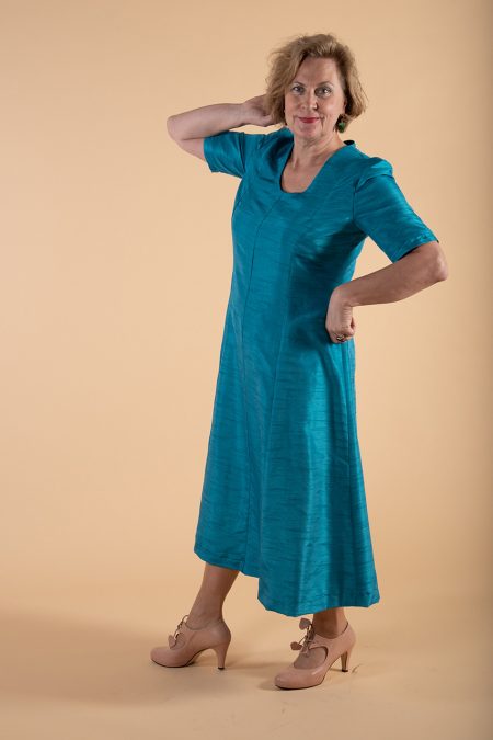 Kuva edestä, säihkyvänsinisen mekon pituus puolisääreen.