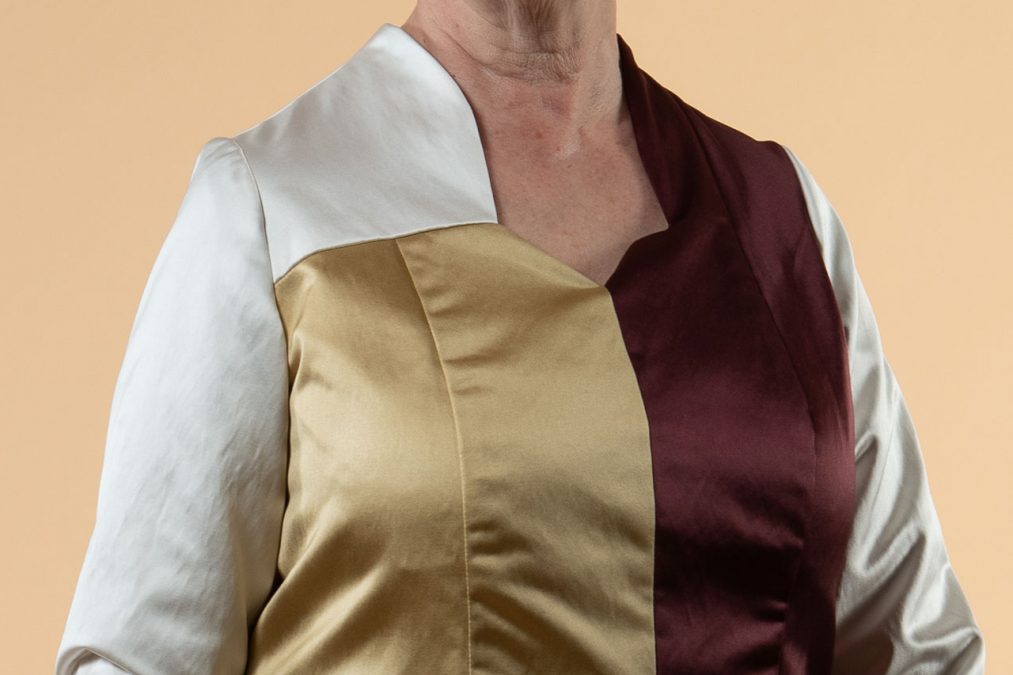 Lähikuva edestä, juhlamekon pääntien leikkaus, miehustan värikontrastit.