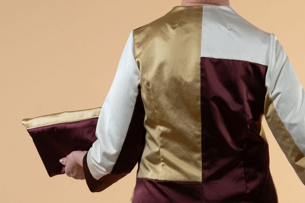 Lähikuva takaa, puuvillasatiinisen mekon selässä väripinnat pystyleikkauksin.