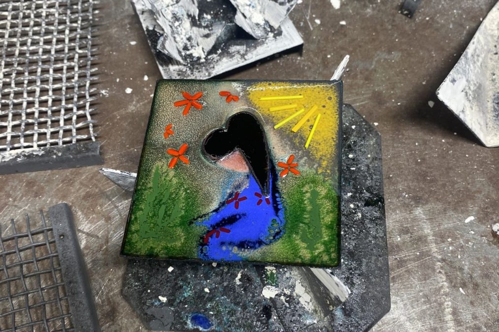 Tyttöä esittävä emalikoru