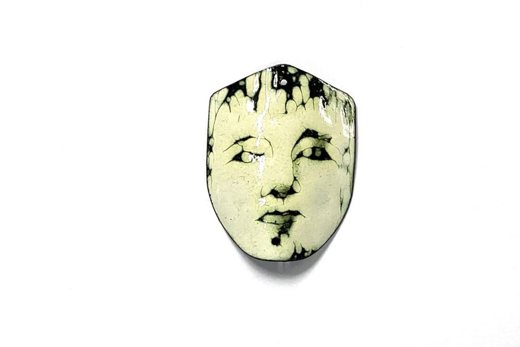 Ihmisen kasvoja esittävä emalikoru