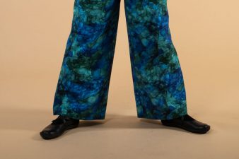 Lähikuvassa housun lahkeet polvesta alaspäin, sinikuviollista laskeutuvaa toimikasta.