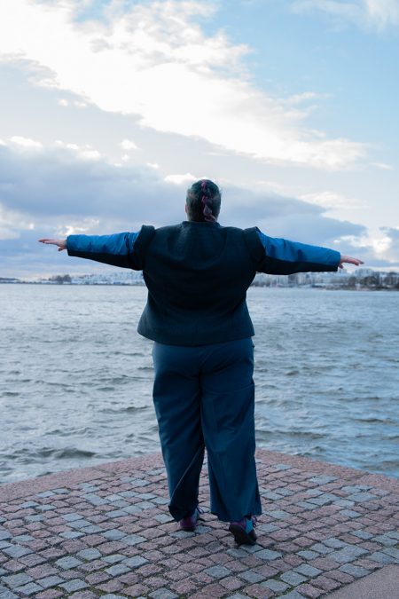 Kuva takaa, sininen jakku ja housut villakangasta, hihoissa myös juhlavaa silkkiä.