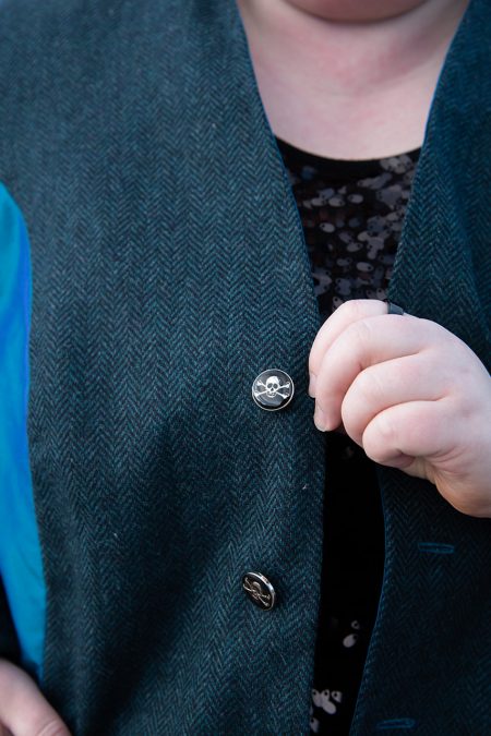 Lähikuva edestä, sinisen jakun yksityiskohtana pääkallonapit.