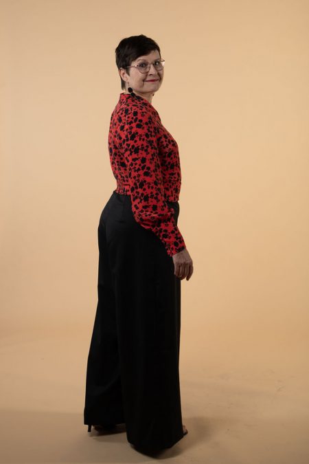 Kuva sivulta, tyylikäs housuasu, jossa leveät, laskeutuvat housut sekä vyötäröltä istuva yläosa.