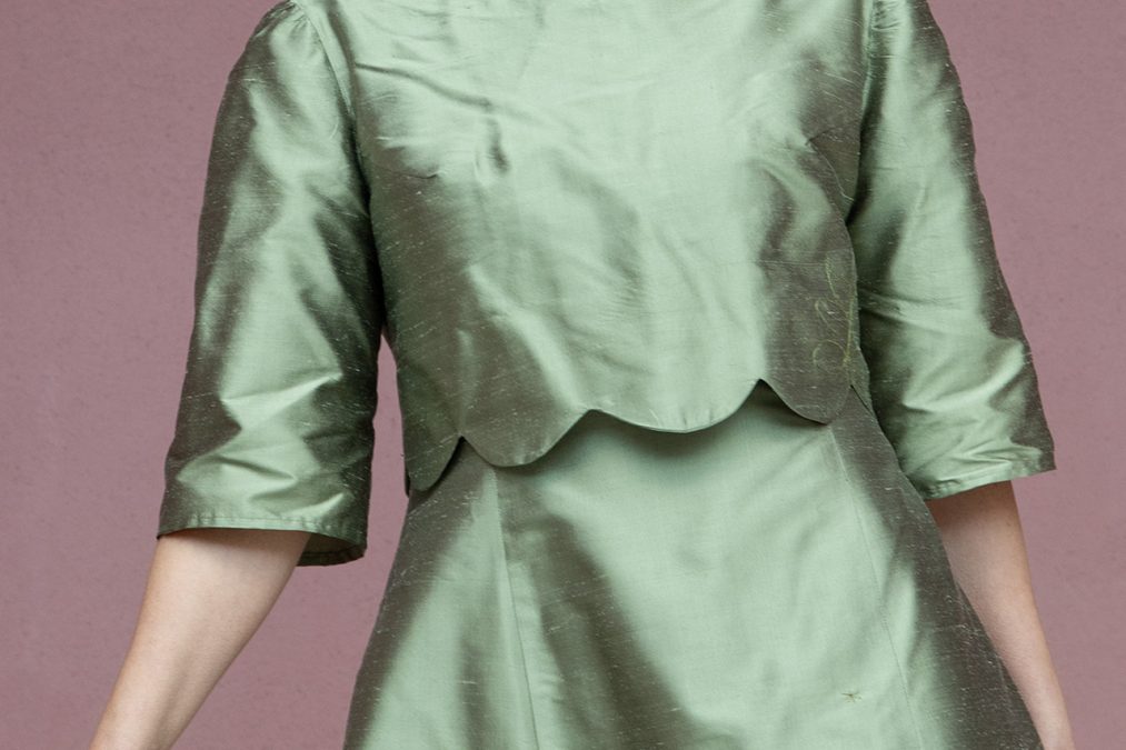 Kuva takaa, sammalenvihreä silkkimekko, lyhyet hihat ja kellotettu helma.