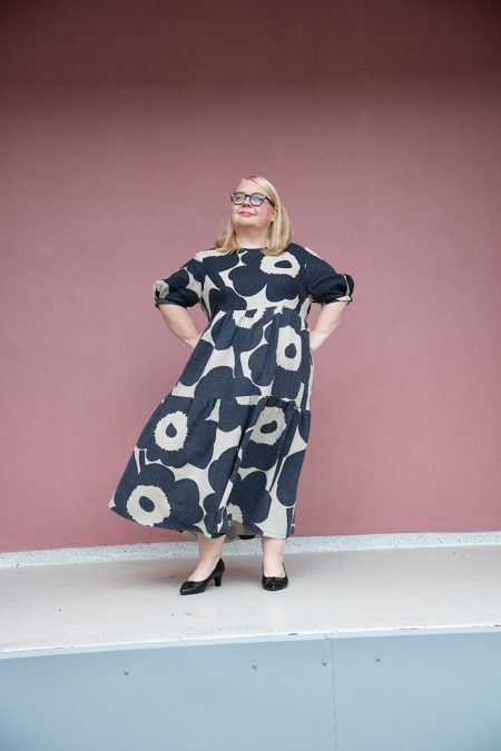 Kuva edestä, Unikko pellavakankaasta valmistettu frillamekko liehuu tuulessa.