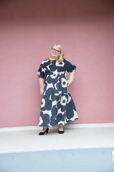 Kuva edestä, leveähelmainen frillamekko puolipitkillä hihoilla, kankaana sinikukkainen Unikko pellava.