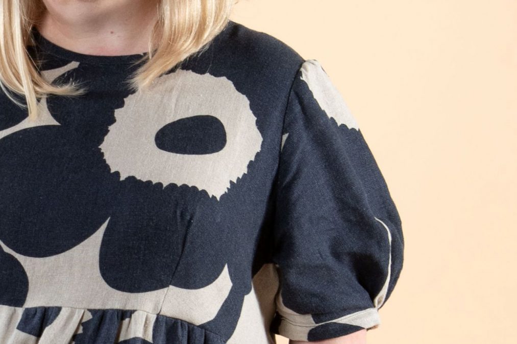 Lähikuvassa miehustaa, pyöreä pääntie, istuvat leikkaukset ja runsaat puolipitkät hihat.