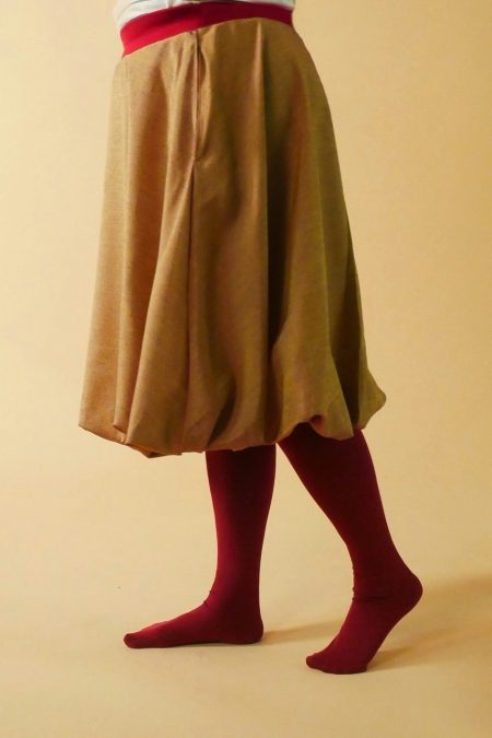 Kuva sivulta, kultaan ja burgundinpunaiseen siftaavasta kankaasta valmistettu pallohame.