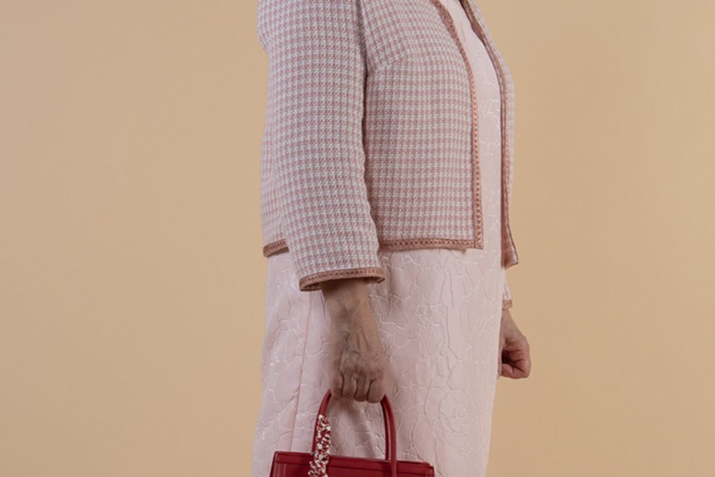 Lähikuvassa pikkuruudullinen Chanel-tyylinen jakku ja vaalea pinkki kotelomekko.