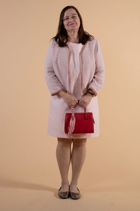 Kuva edestä, Chanel-tyylinen jakku ja hihaton kotelomekko, punainen käsilaukku.