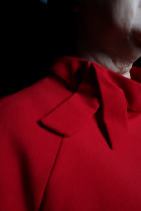 Lähikuvassa punaisen puseron tyylitelty kaulus.