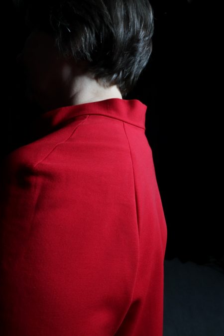 Lähikuvassa punaisen puseron raglanlinjat ja kaulus.