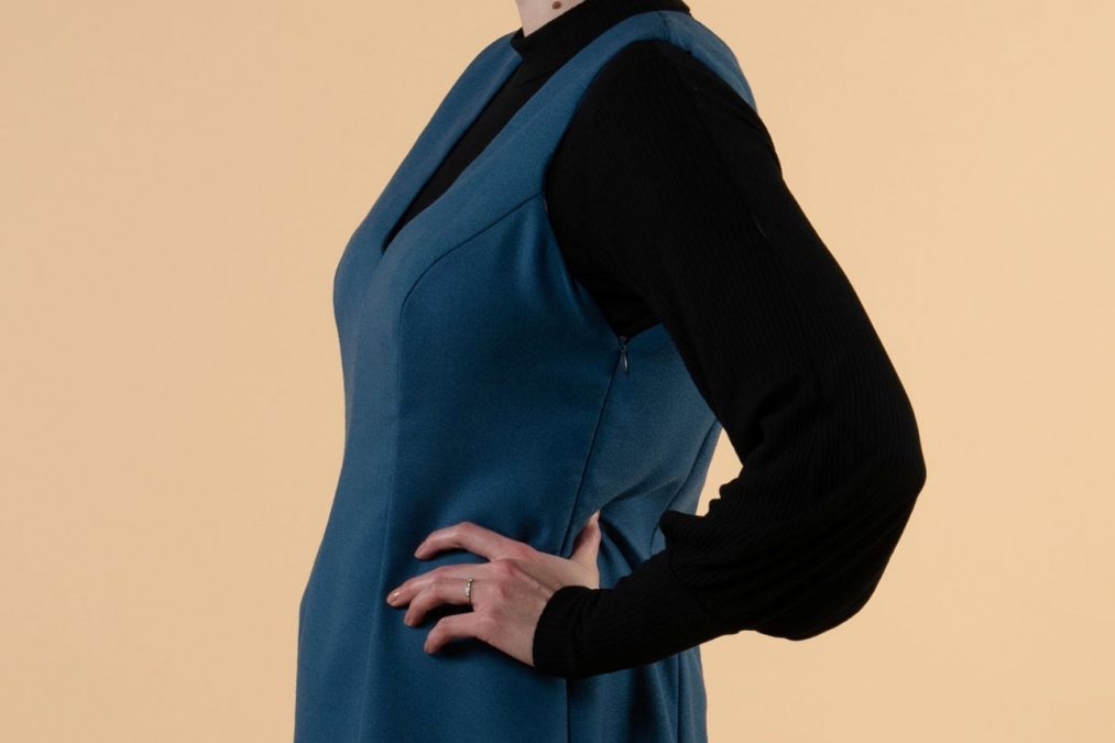 Lähikuvassa sinisen liivimekon sivuprofiili, istuva prinsessaleikkaus.