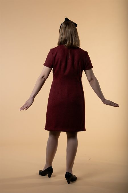 Kuva takaa, linjakas kotelomekko viininpunaisesta villakankaasta.