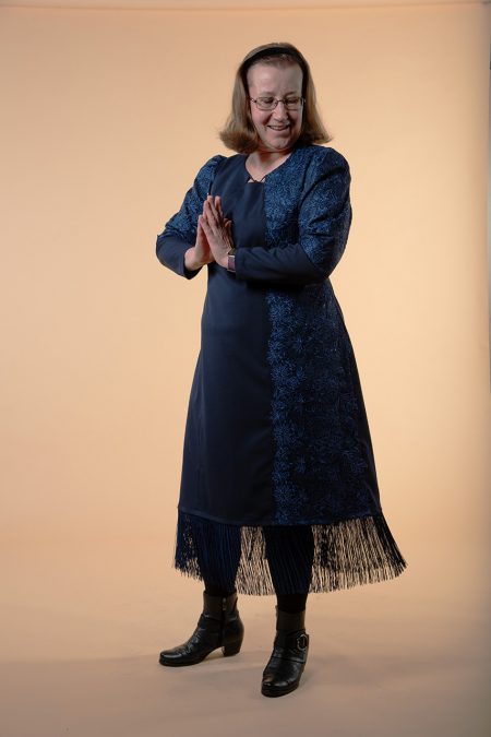 Kuva edestä, sininen pitkähihainen juhlamekko villasekoitekangasta, helmassa pitkät hapsut.