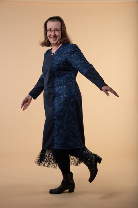 Kuva vasemmalta sivulta, jossa juhlamekon villakankaan päällä on kaistale sinistä pitsikangasta.