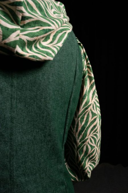 Lähikuvassa liivimekon leikkauslinjoja selässä, puseron huppua ja hihaa.