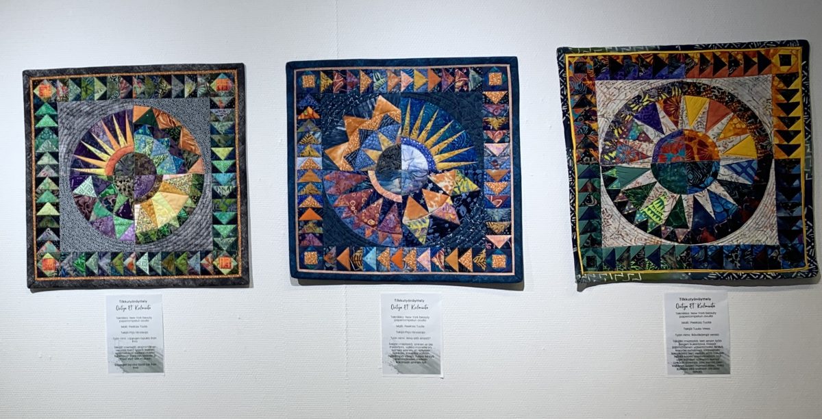 Neliön muotoisia tilkkutöitä kolmelta eri tekijältä. Töissä sama kuvio eri värein toteutettu. Ympyrän muoto keskellä, joita kiertää lentävät hanhet-tekniikalla toteutetut palat. 